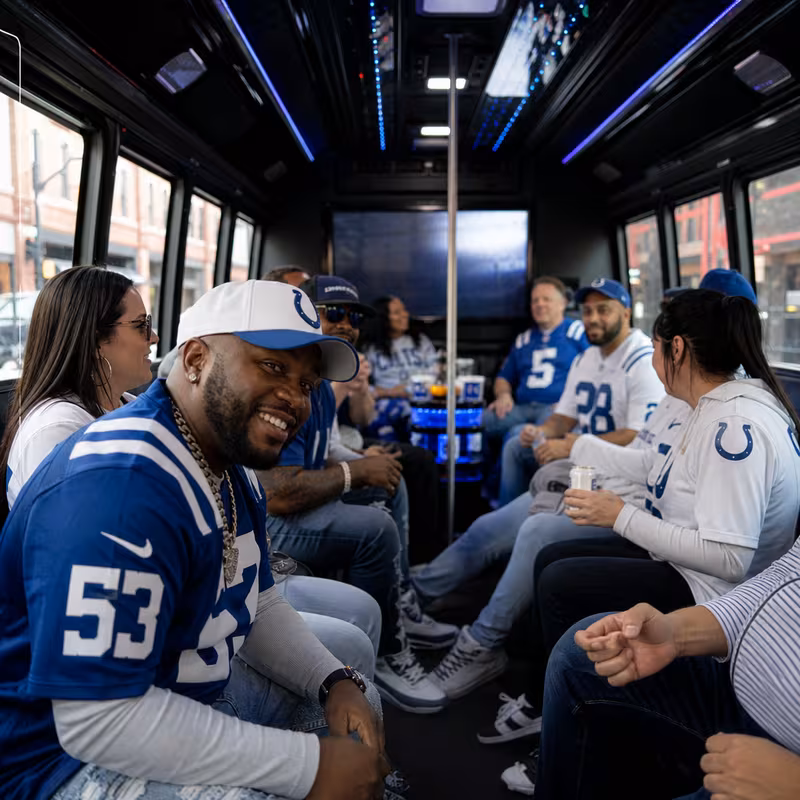 Group boarding a white charter bus for Sporting Event Transportation transportation in Indianapolis