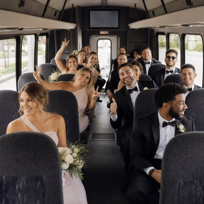 Group boarding a white charter bus for Wedding Transportation transportation in Indianapolis